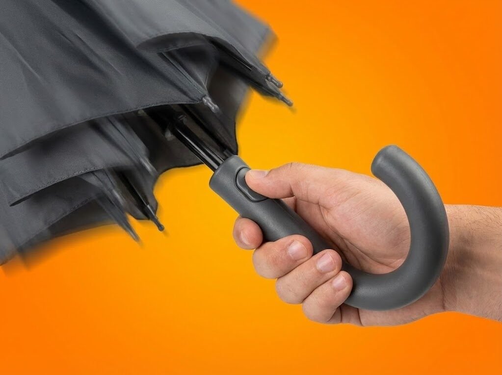 Mão a pressionar o botão de abertura automática do ZeroGotas