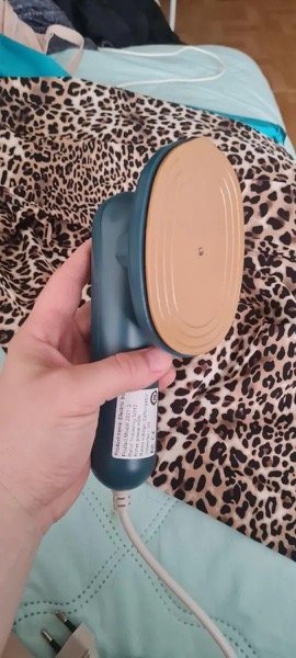 Mini Ferro de Passar compacto ao lado de roupa perfeitamente alisada