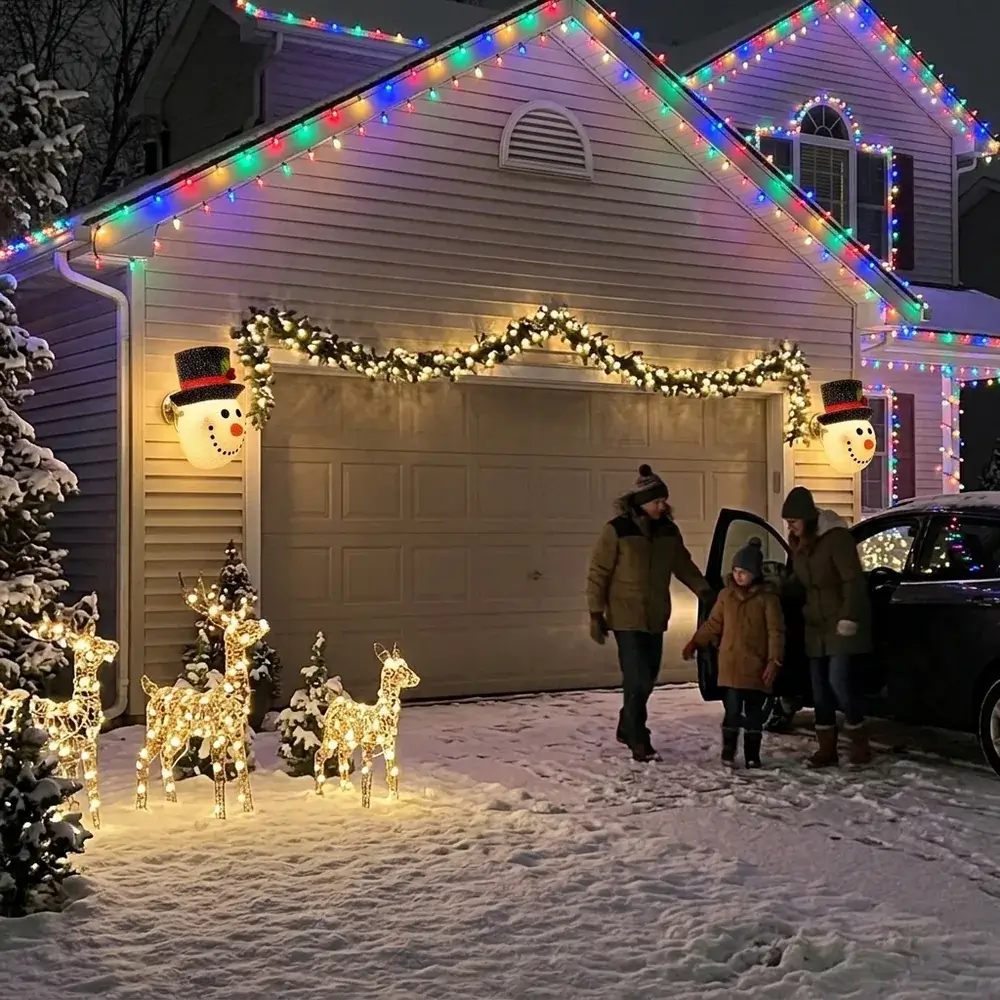 Dois bonecos de neve acesos, um de cada lado da porta da garagem de uma moradia decorada
