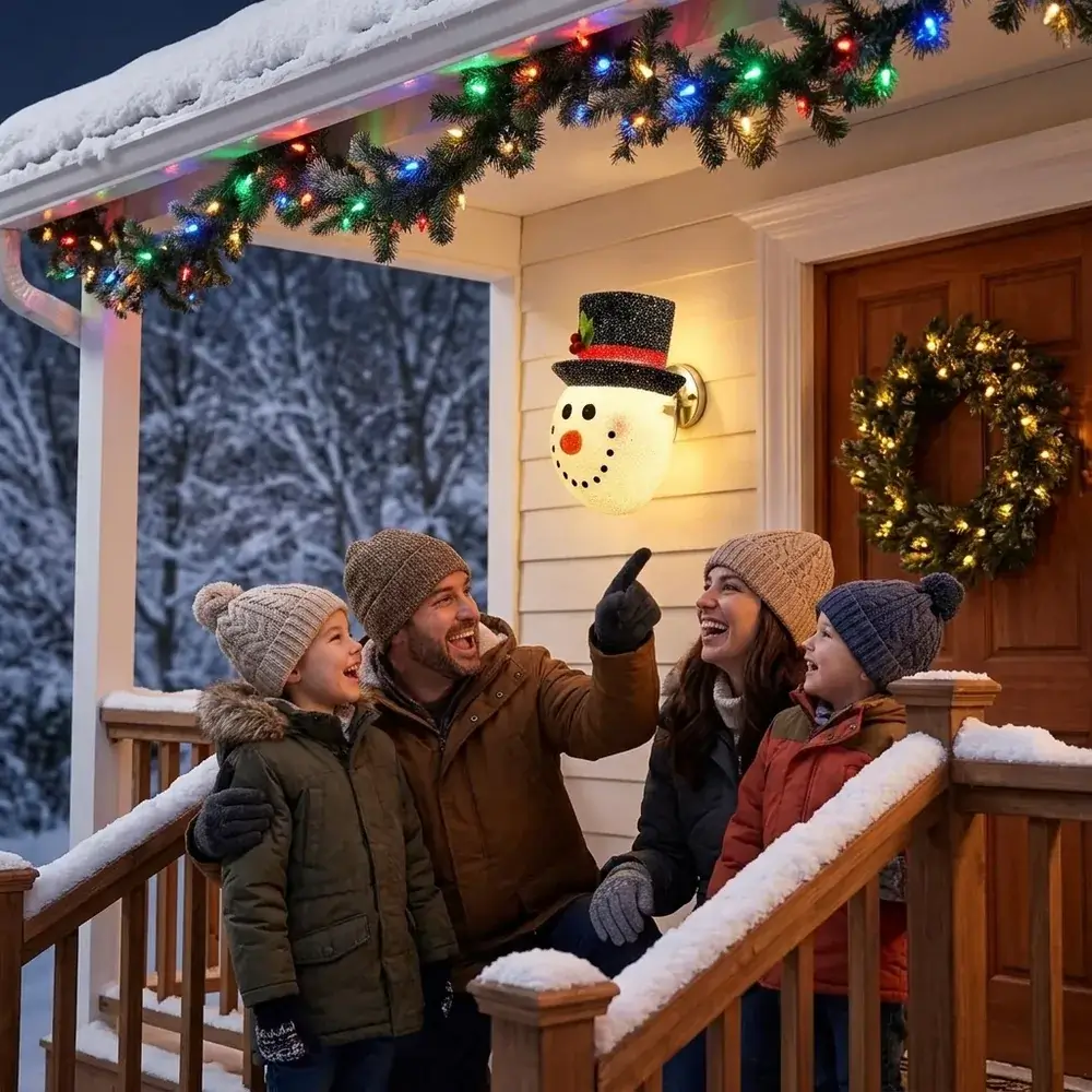 Família à porta de casa à noite, com as crianças a apontar para o boneco de neve aceso no candeeiro