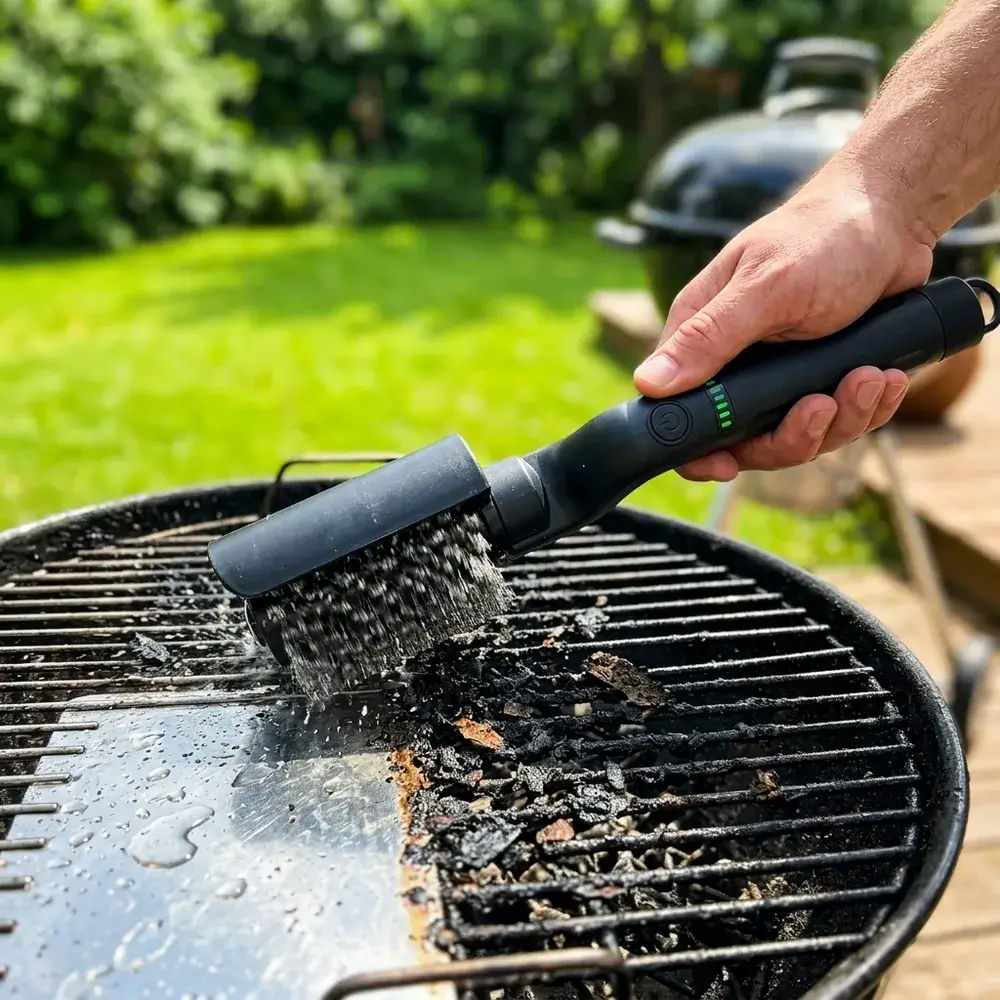 Spazzola elettrica passata su una griglia del barbecue, con le barre pulite e lucide